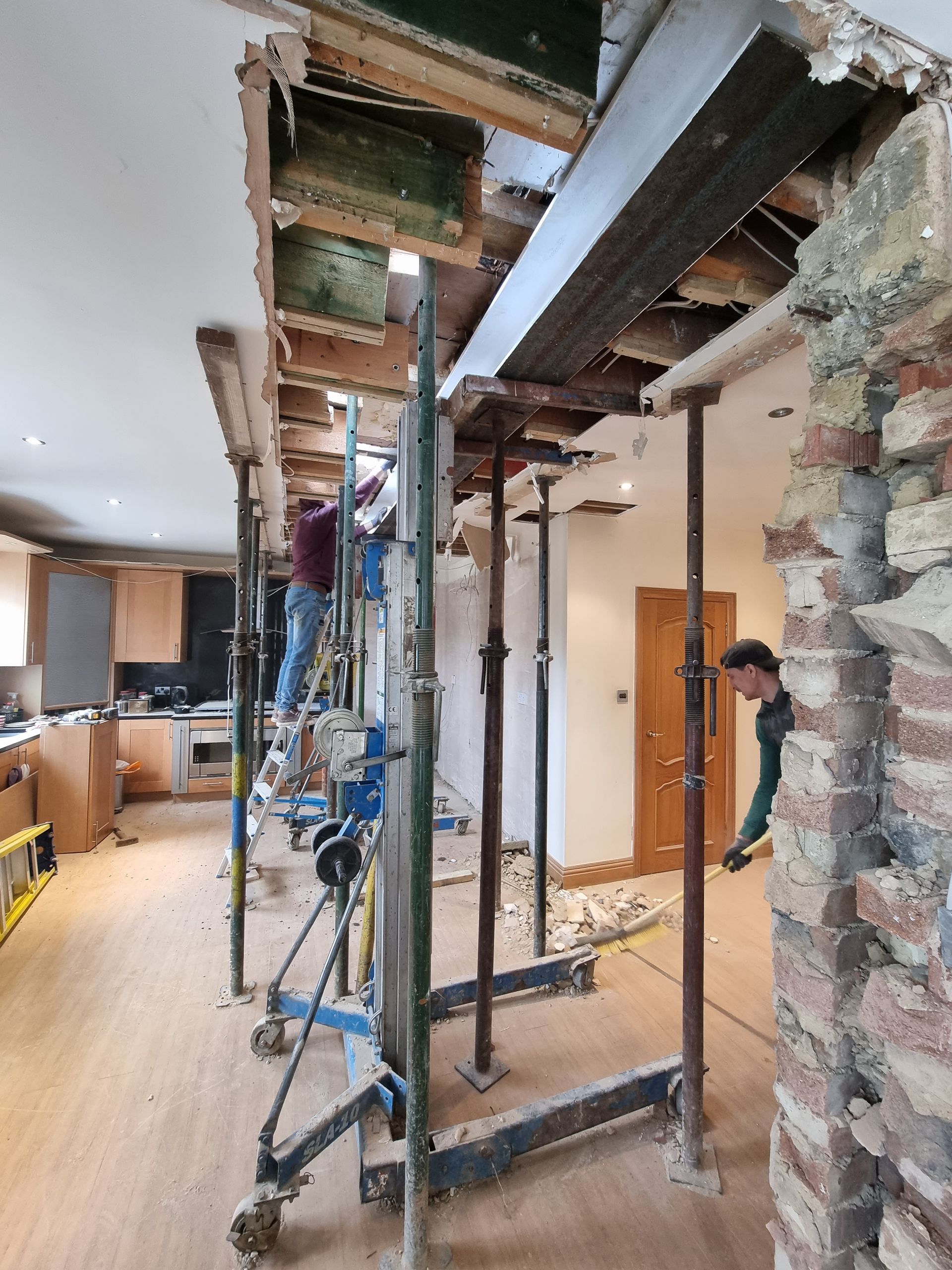 A man is standing on a ladder in a room with scaffolding.