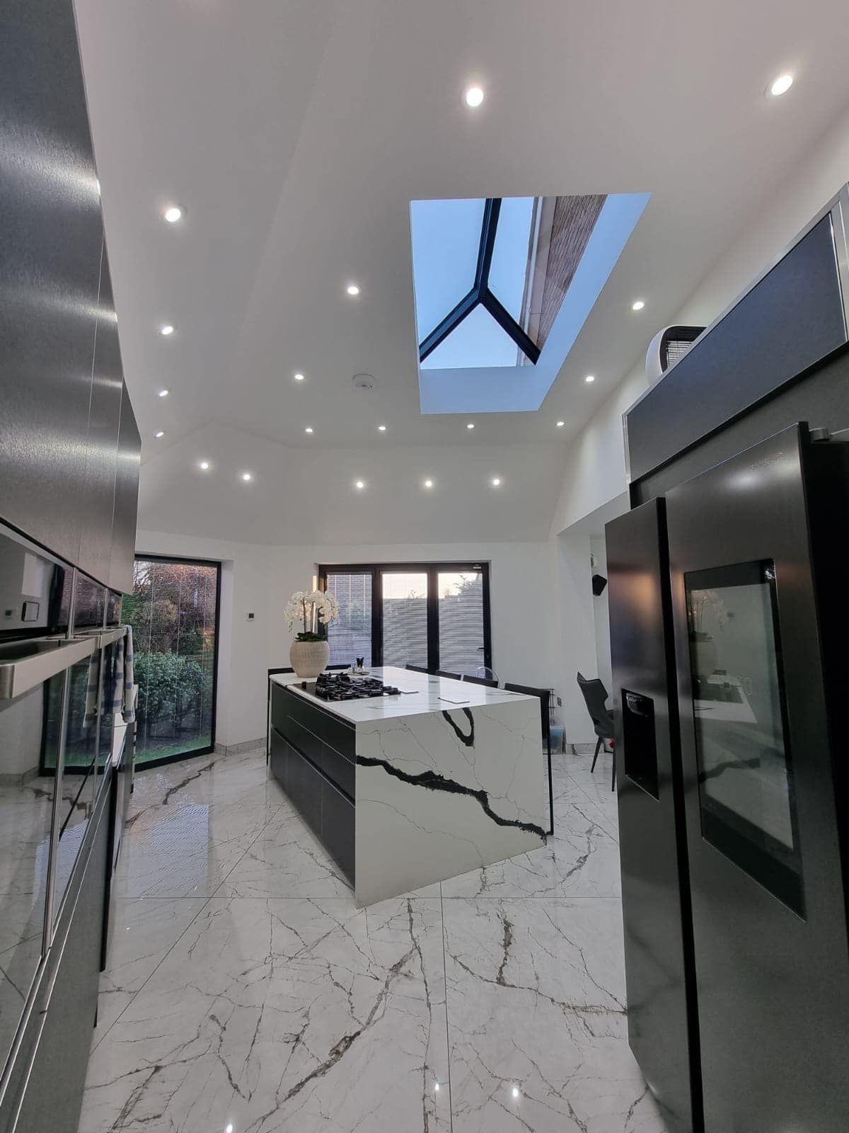 A kitchen with a large island and a skylight in the ceiling.