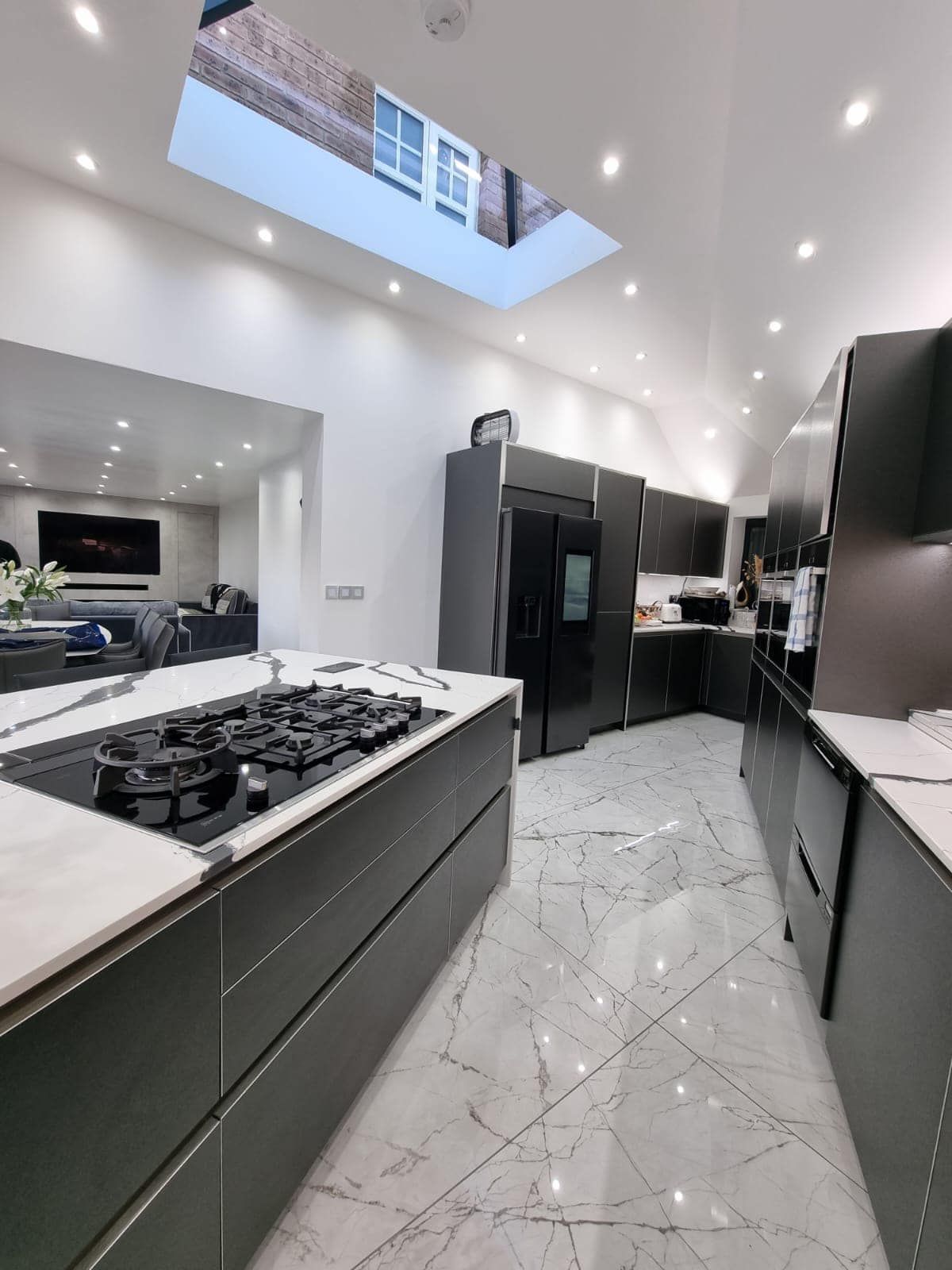 A kitchen with a stove top oven and a skylight above it