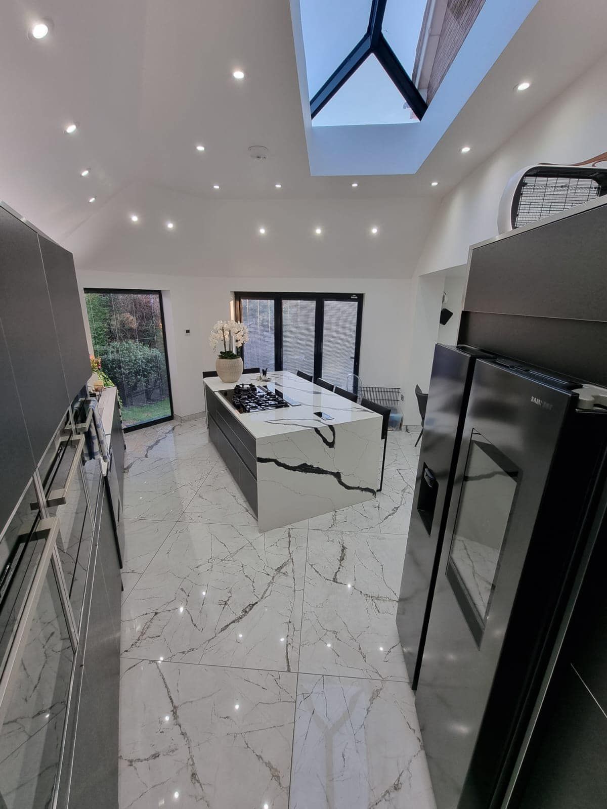 A kitchen with a large island and a skylight in the ceiling.
