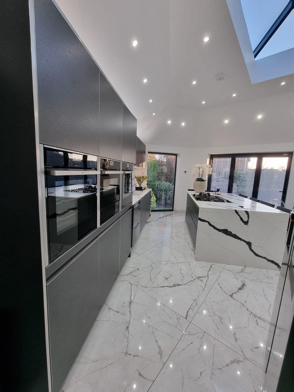 A kitchen with a large island in the middle and a skylight in the ceiling.
