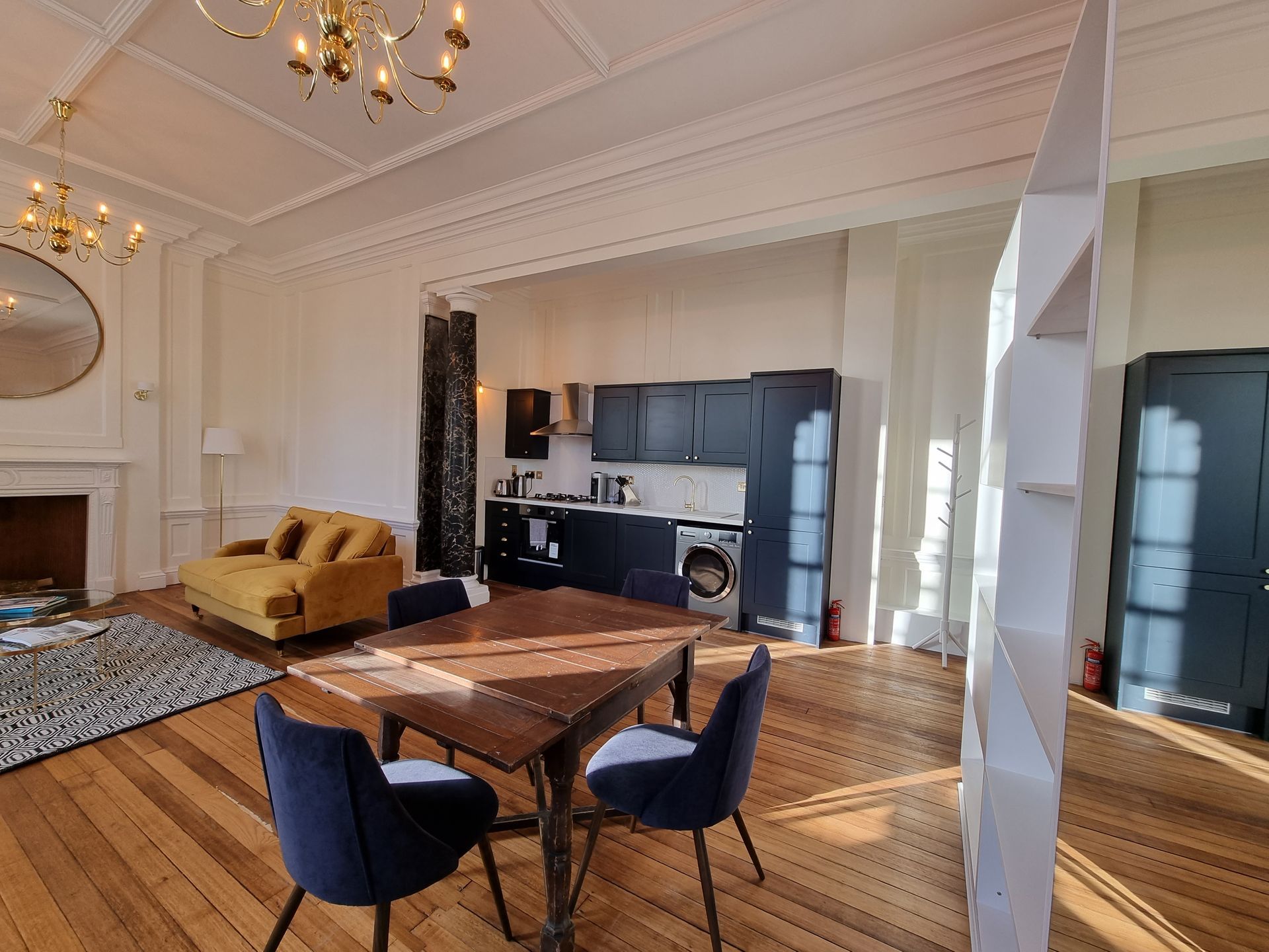 There is a table and chairs in the middle of the room.