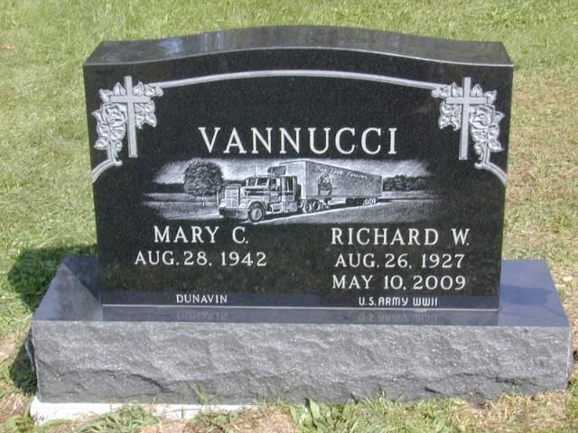 Black granite Vannucci gravestone with engraved photos and names, set on a gray base in a cemetery