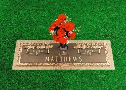 MATTHEWS grave marker with red flowers on green grass