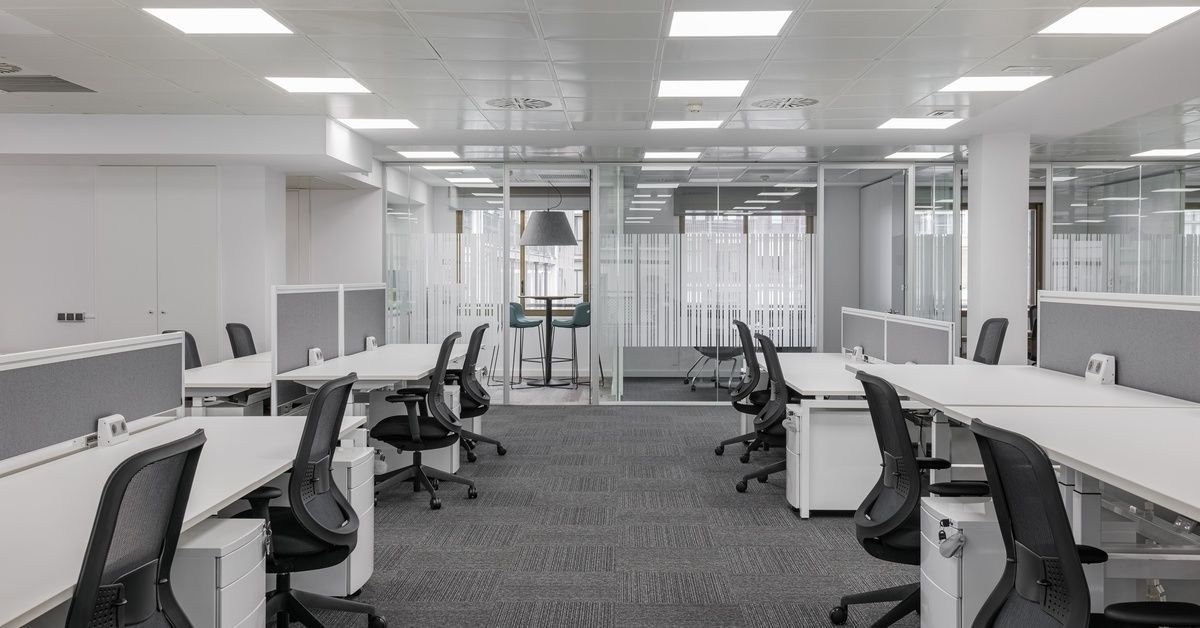 A large office space with various spaces such as collaborative work desks, private glassed-in offices, and conference rooms.