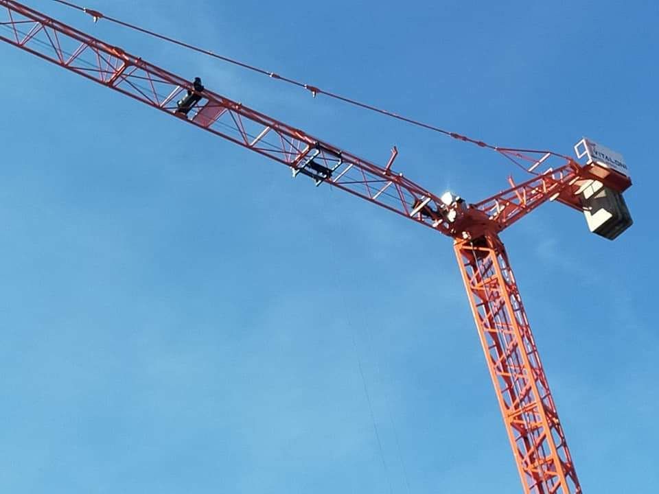una gru rossa è appesa a un cielo blu