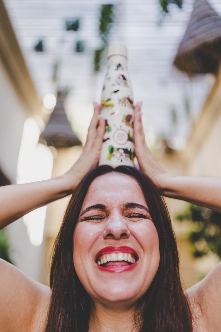 Mulher a segurar uma garrafa térmica da Cool Bottles em cima da cabeça