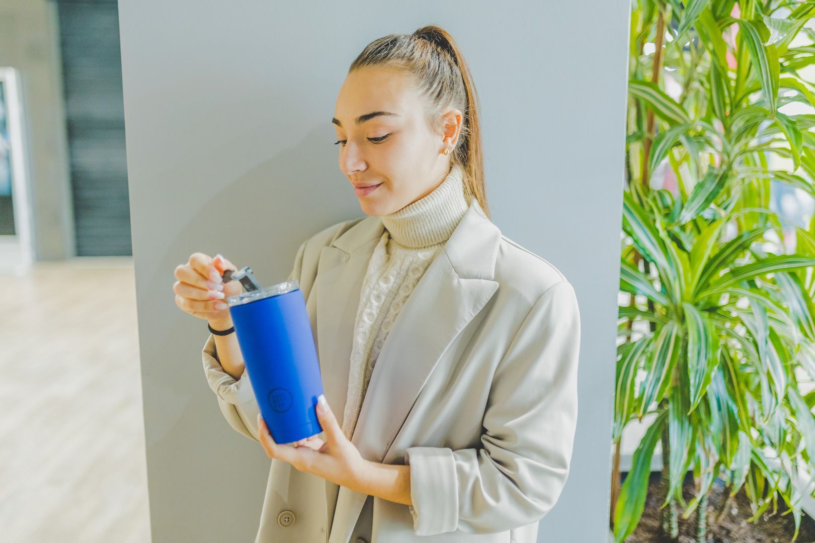 Mulher no escritório com copo térmico azul da Cool Bottles