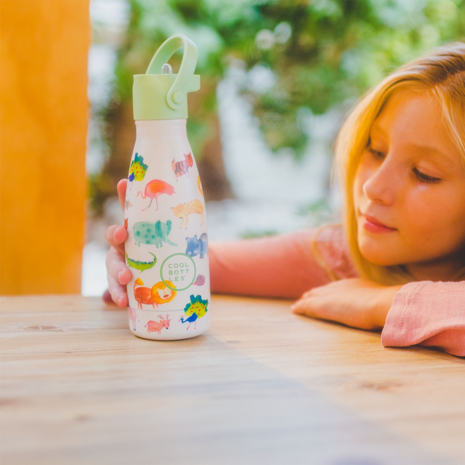 Menina a olhar para a garrafa térmica da Cool Bottles com desenhos