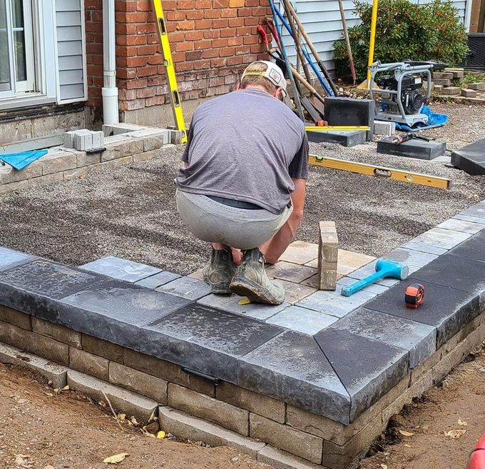 Landscape construction worker laying interlock pavers