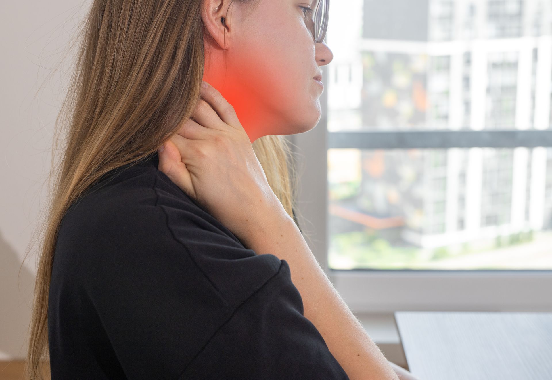 Person holding neck with red pain highlight.