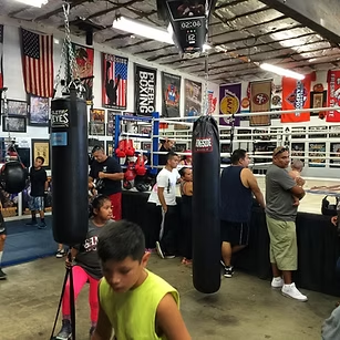 A group of people are in a boxing gym with a sign that says cheering boxing
