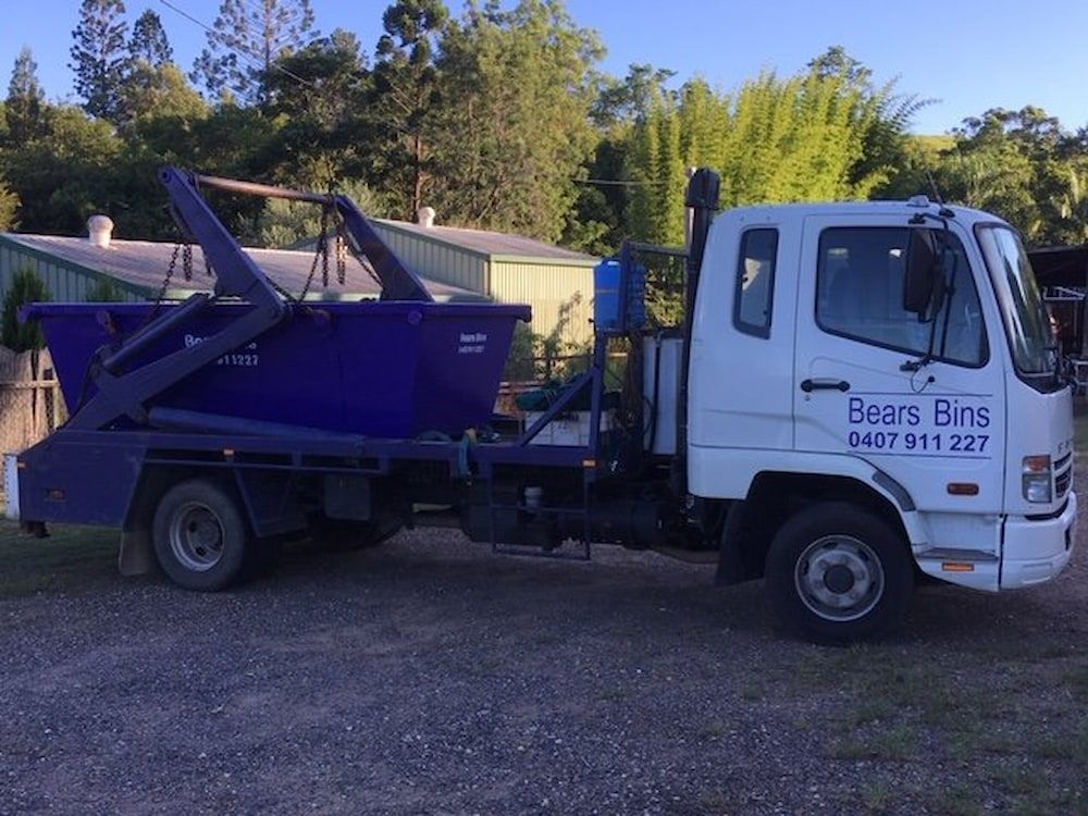 A Blue And White Dump Truck Is Parked On The Side Of The Road — Bears Bins Skip Hire In Meridan Plains, QLD