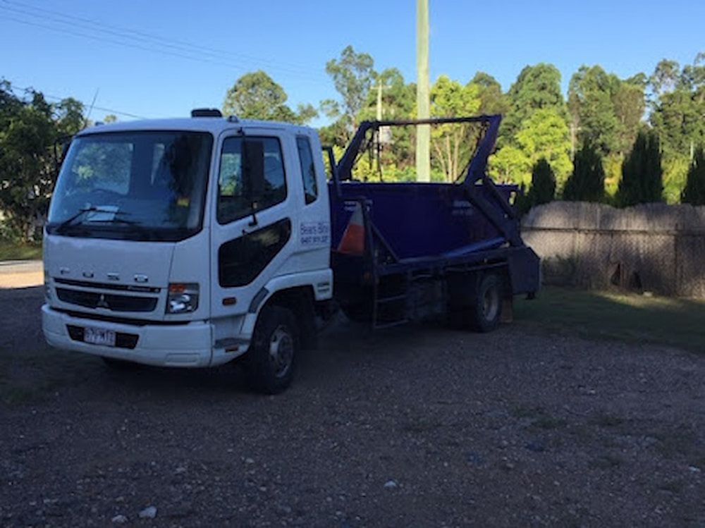 A White Truck Is Parked On The Road Carrying A Dumpster — Bears Bins Skip Hire In Mountain Creek, QLD