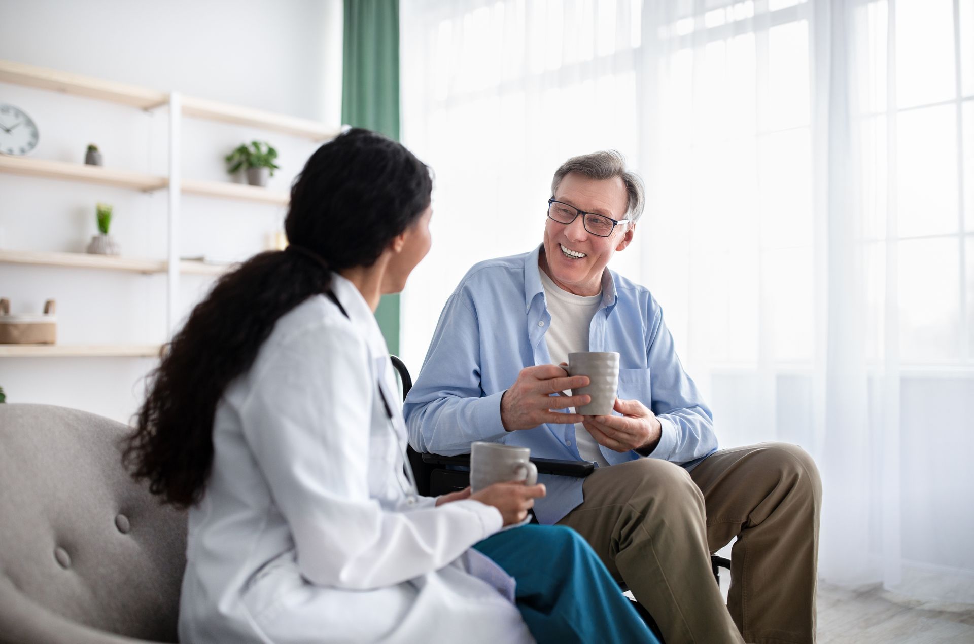 A doctor consulting a patient in a chair, showcasing personalized home health services at home.