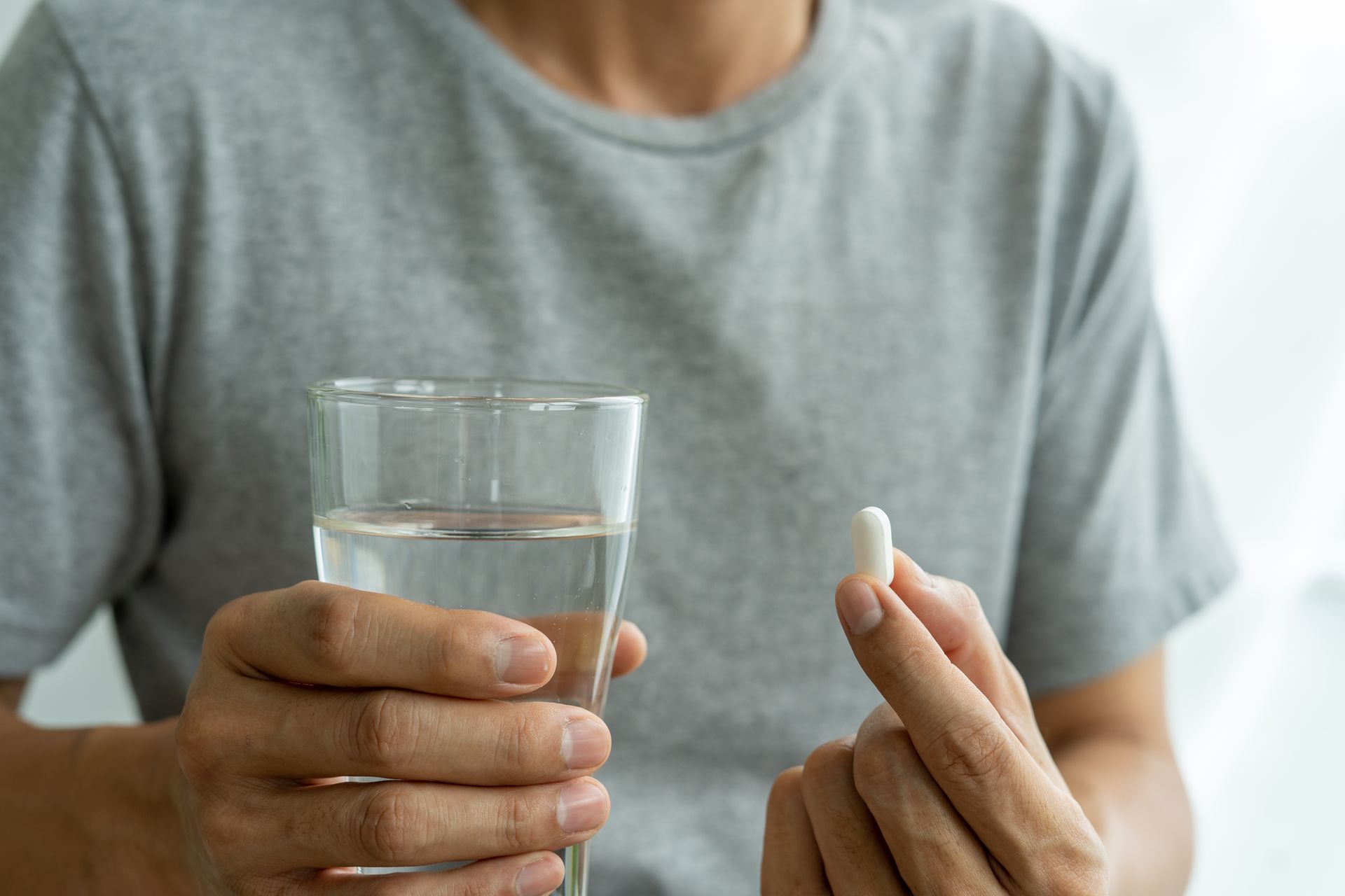 Man taking a tablet of myo-inositol for men's fertility benefits.