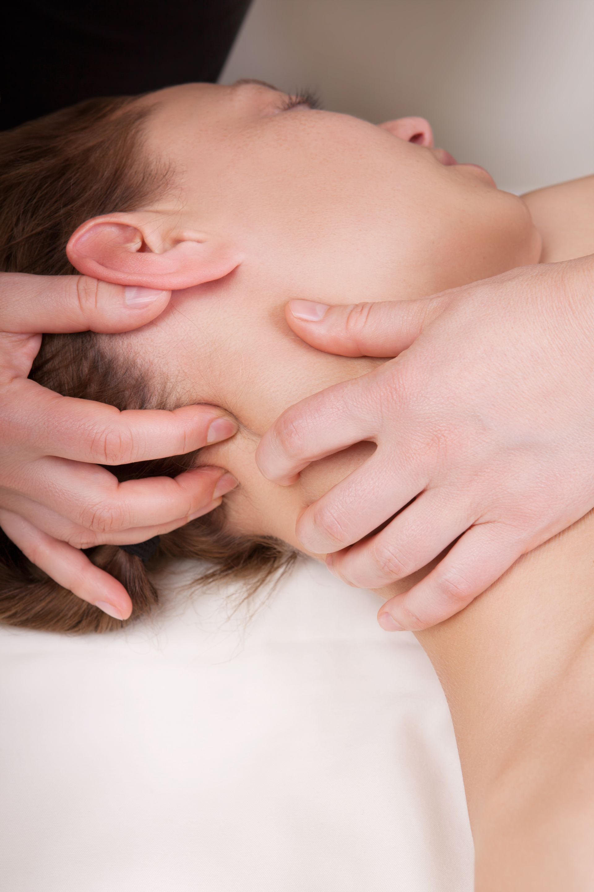 acupuncturist using acupuncture on a young woman's neck muscles to help improve the success rate of IVF