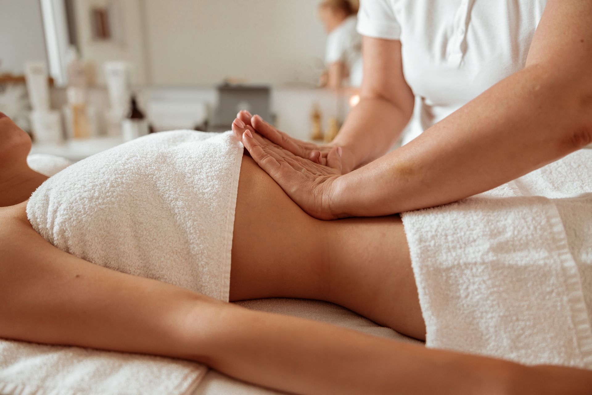 a woman is laying on a table getting a massage on her midsection as a part of her postpartum massage