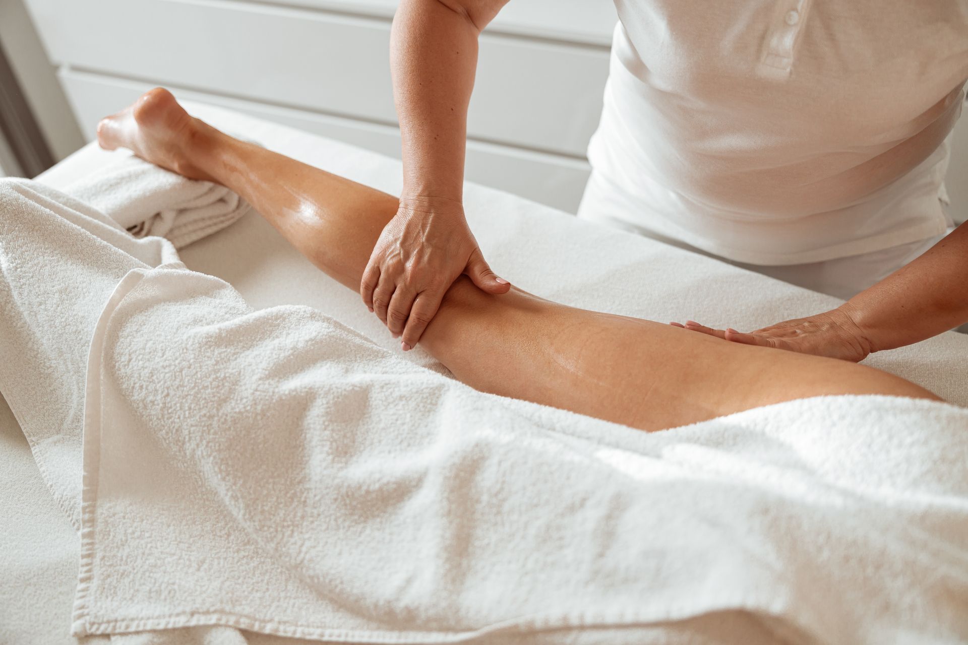 a woman is getting a massage on her leg for the benefits of post partum massage