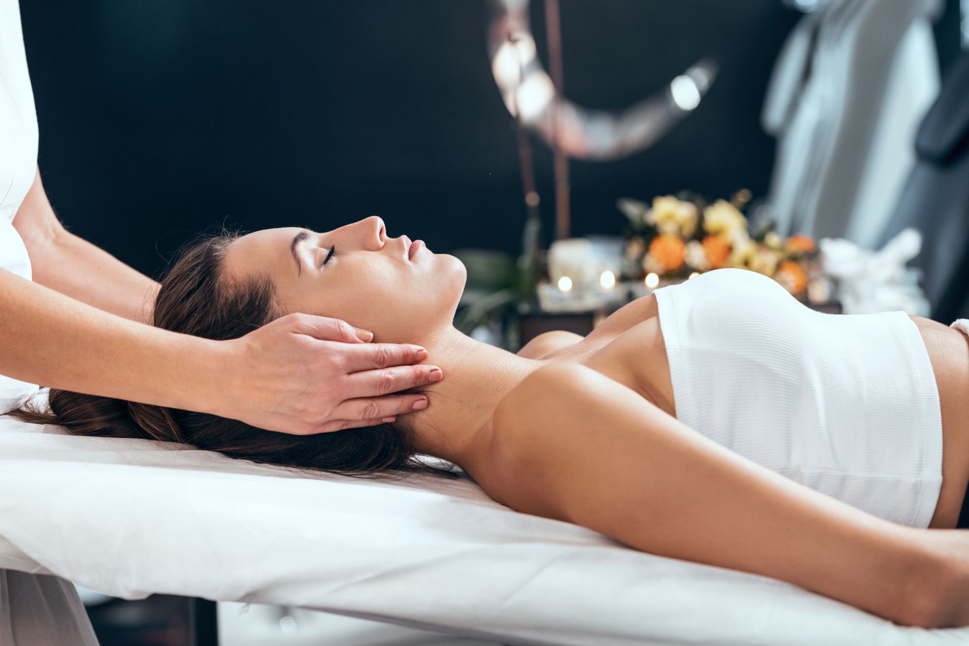 A woman is lying on a massage table getting a massage to promote fertility