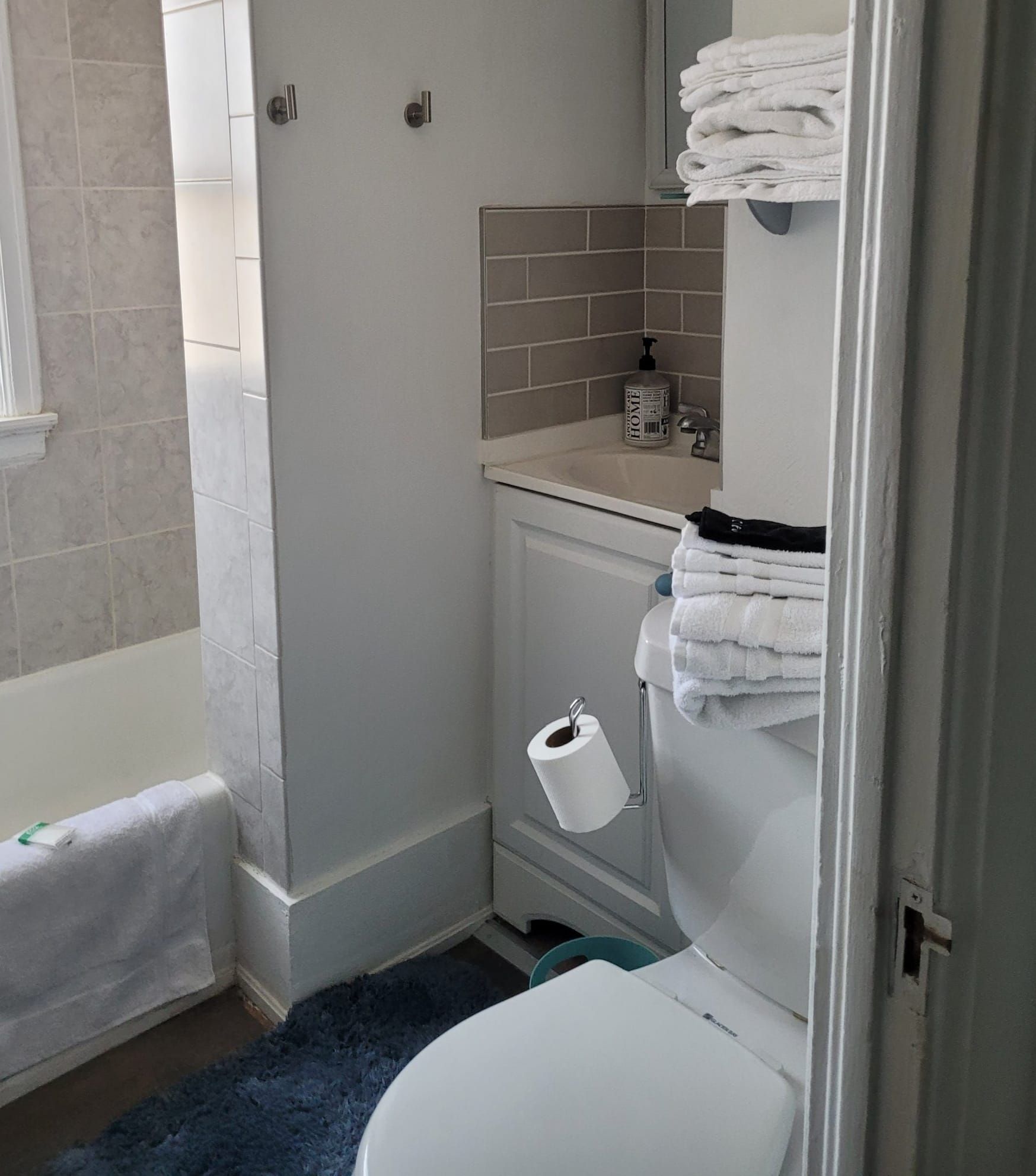 A bathroom with a toilet , sink , and bathtub.
