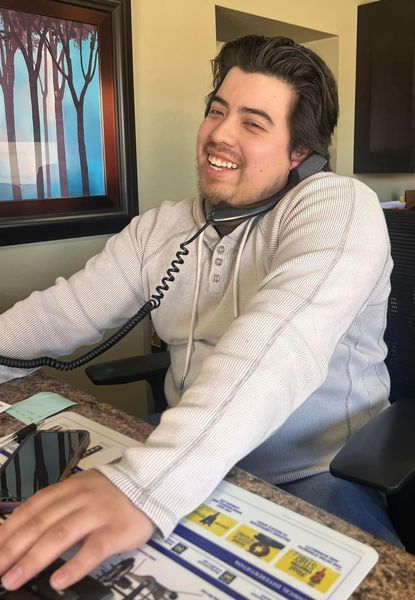 Team Member at Desk Talking on a Phone | Auto Quality Sales & Service