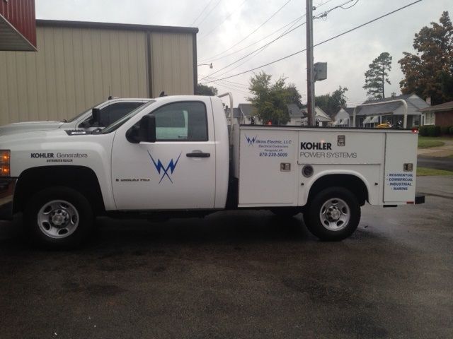 A white utility work truck parked outside, featuring branding for Kohler Power Systems and a lightning bolt logo.