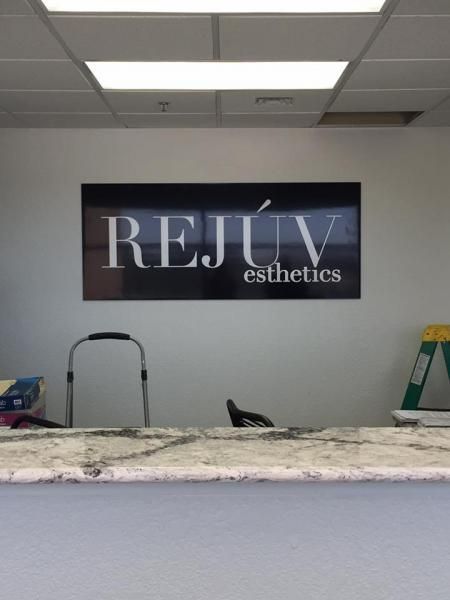 A reception desk with a sign on the wall reading 