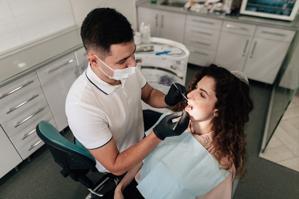 Dentist examining a woman's teeth in a dental clinic in Meridian, ID