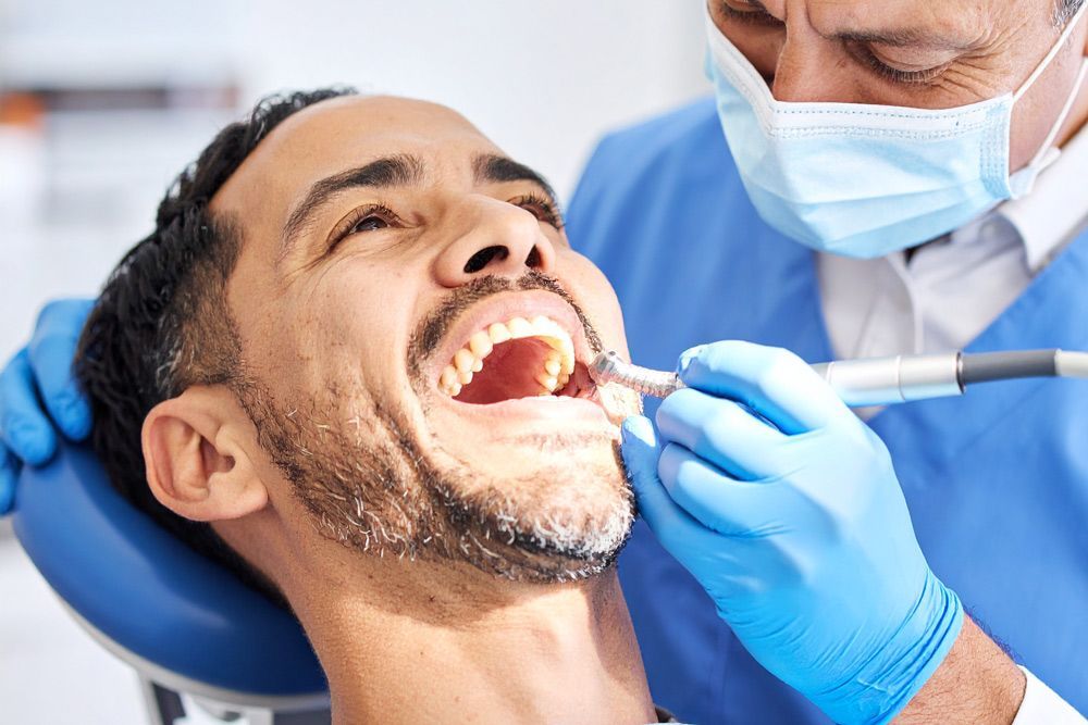 Dentist cleaning patient's teeth in Meridian, ID