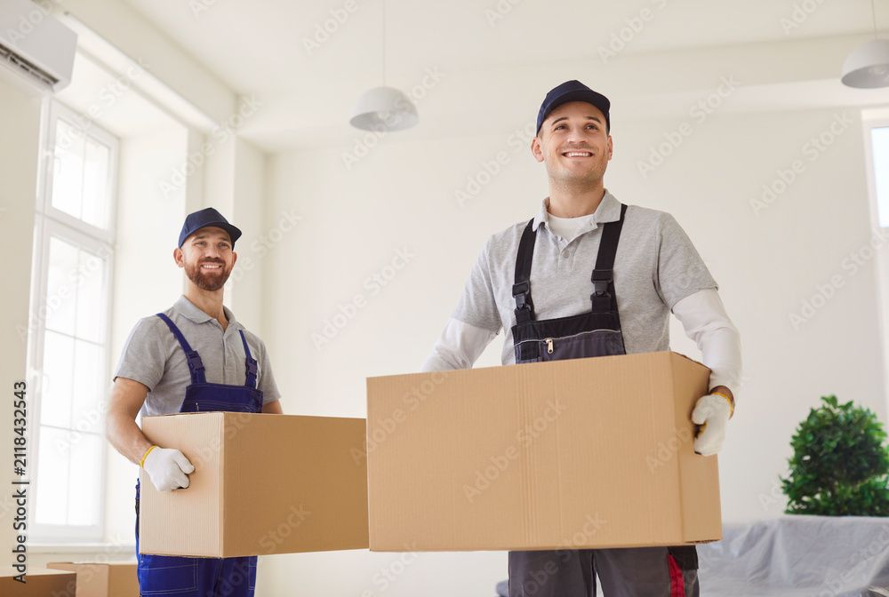 Person carrying a large box up a staircase in a bright hallway