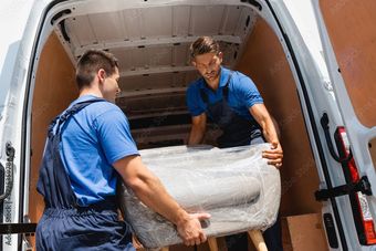 Delivery worker bringing a single piece of furniture to a door