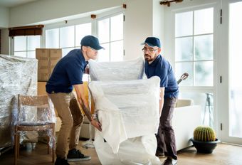 Movers carrying furniture up an apartment stairwell