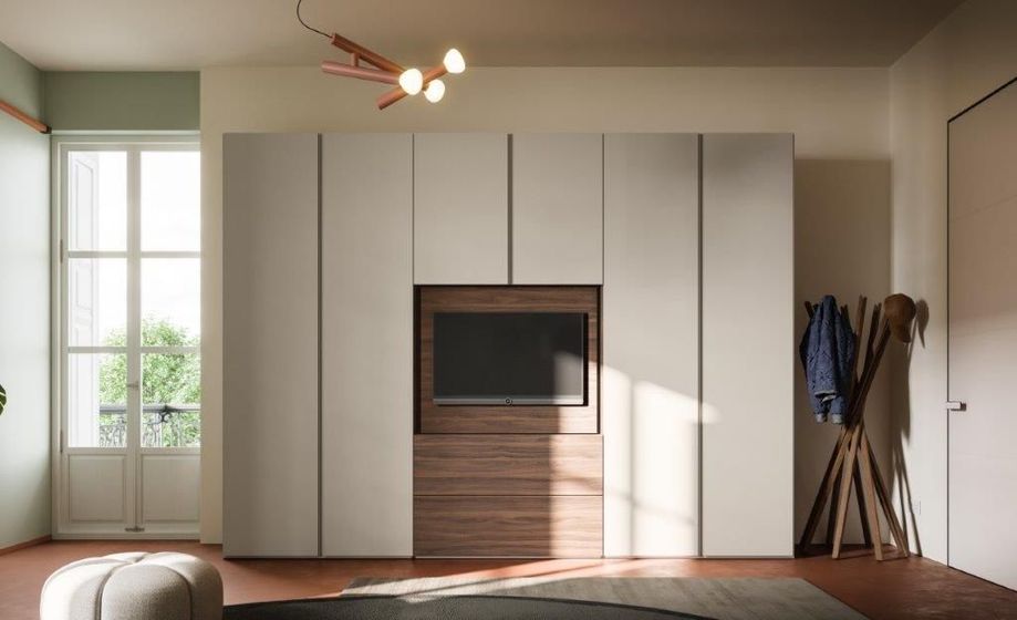 Ampio armadio neutro con TV integrata in una moderna camera da letto; dettagli in legno marrone, appendiabiti.