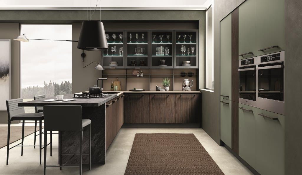 Cucina moderna con mobili in legno, dettagli verdi e un'isola centrale con posti a sedere.