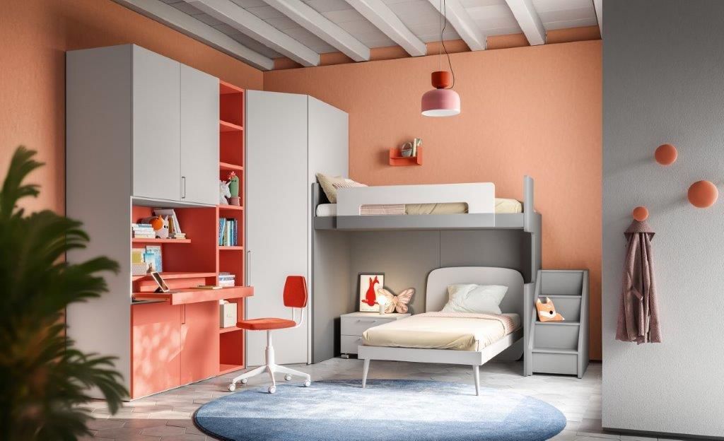 Una cameretta per bambini con letto a castello, scrivania, spazio per riporre gli oggetti e dettagli color corallo.
