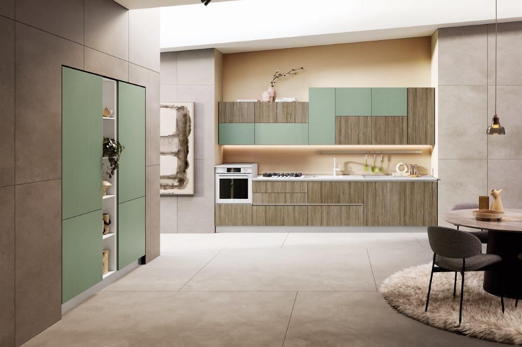 Cucina moderna con mobili verdi, dettagli in legno e pavimento chiaro. Include forno e zona pranzo.