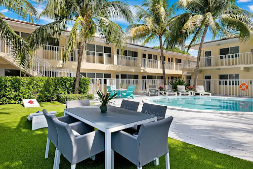 There is a table and chairs in front of a swimming pool.