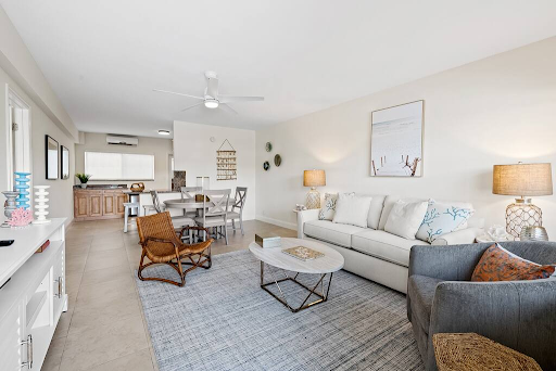 A living room with a couch , chairs , and a coffee table.