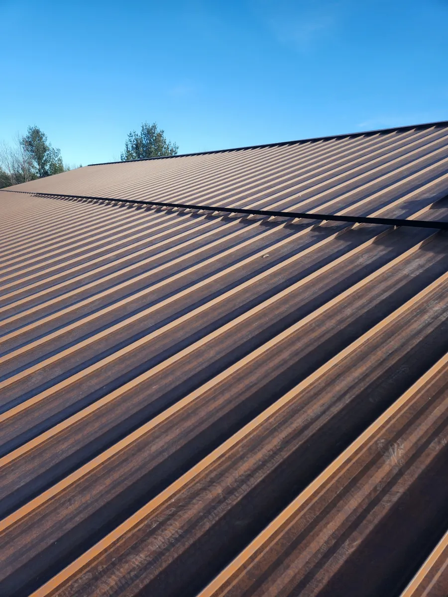 Sunlit corrugated metal roof under a clear blue sky