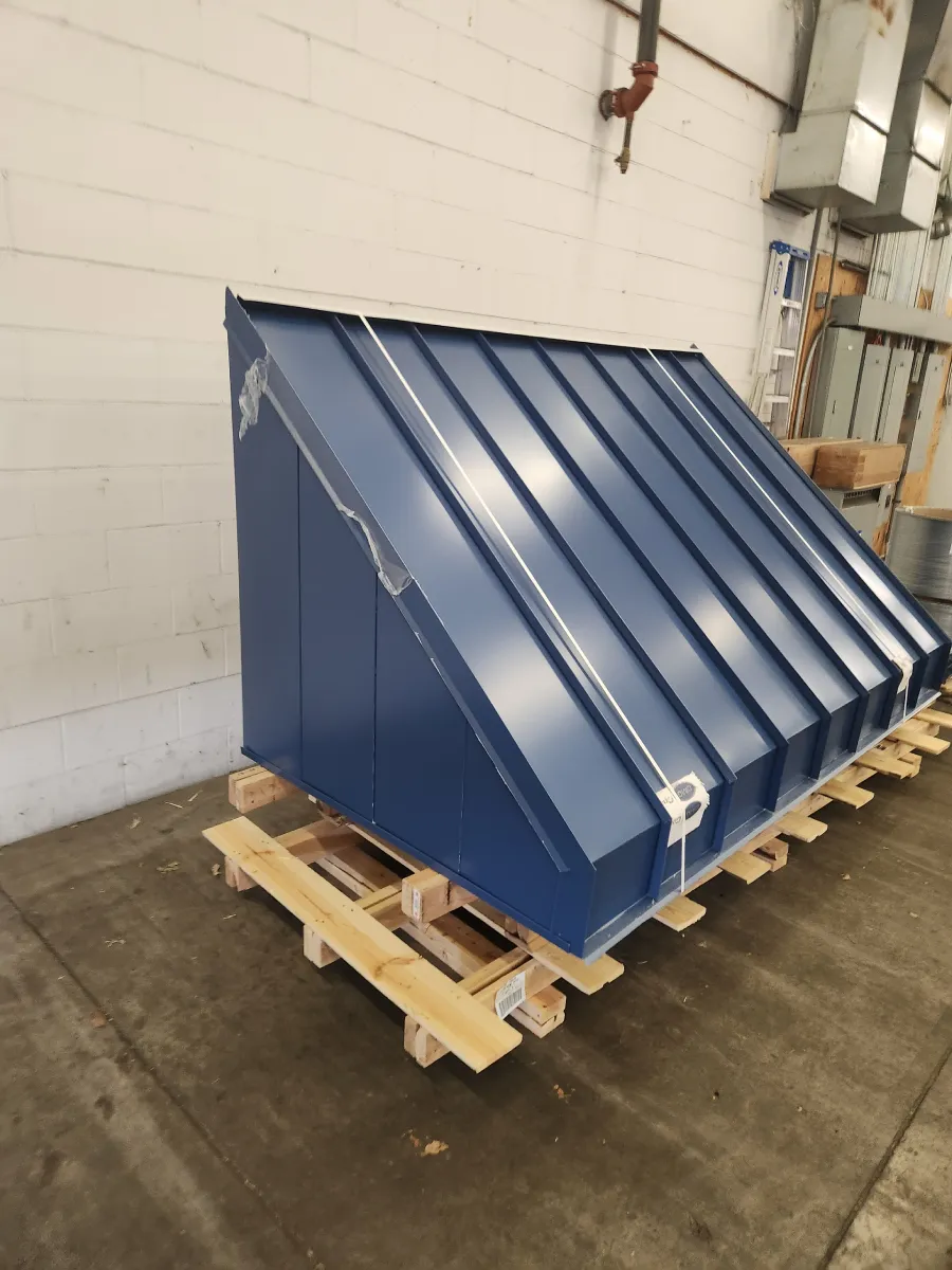 Blue metal industrial bin on a wooden pallet in a warehouse or workshop setting