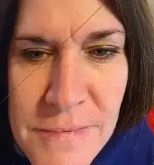 Close-up of a woman’s face with a neutral expression against a blue background