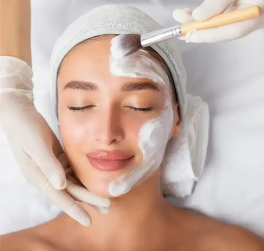 Spa facial treatment with white cream being applied to a relaxed client’s face