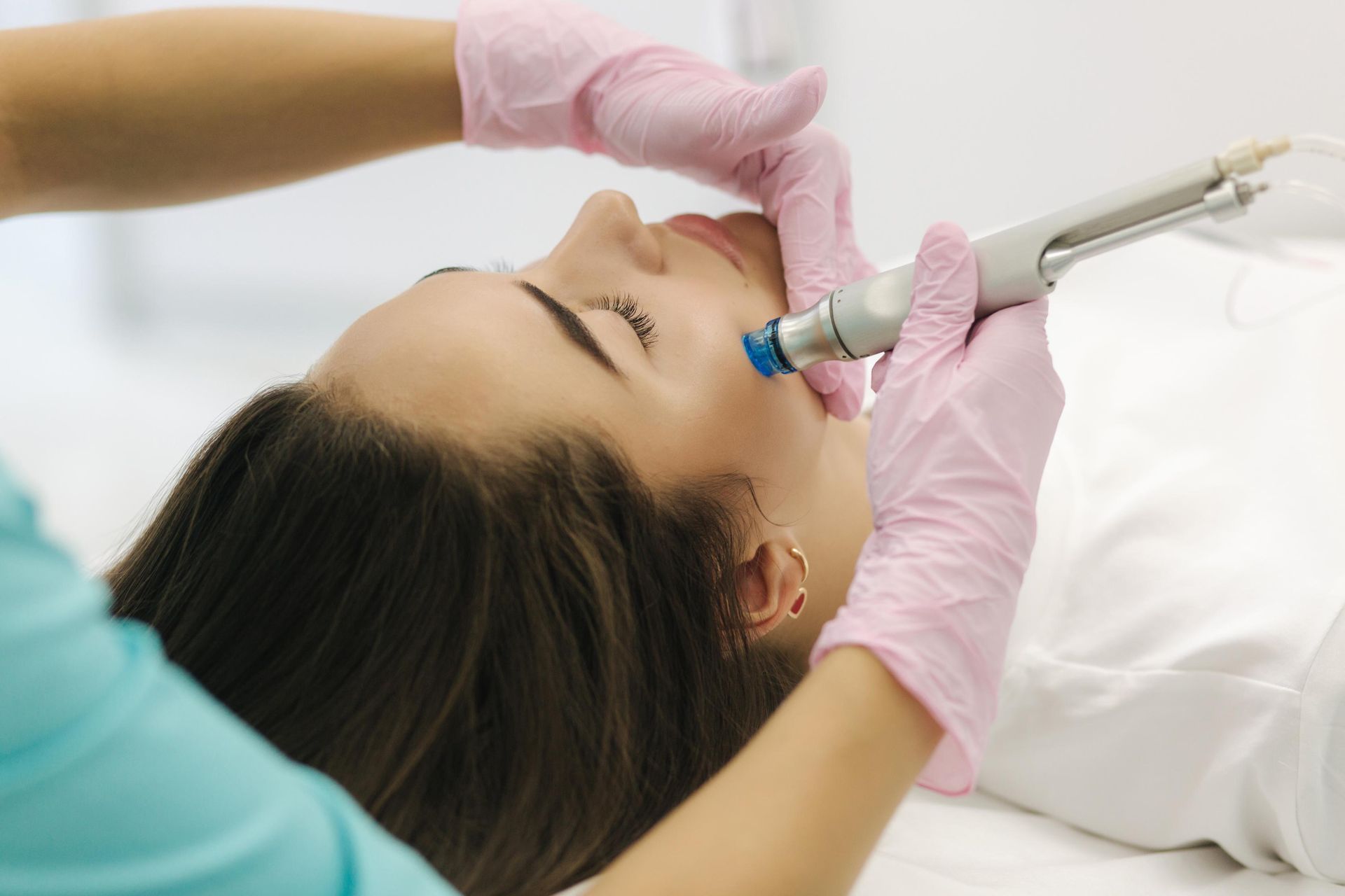 Dental procedure with gloved clinician using a syringe on a patient lying on a treatment chair