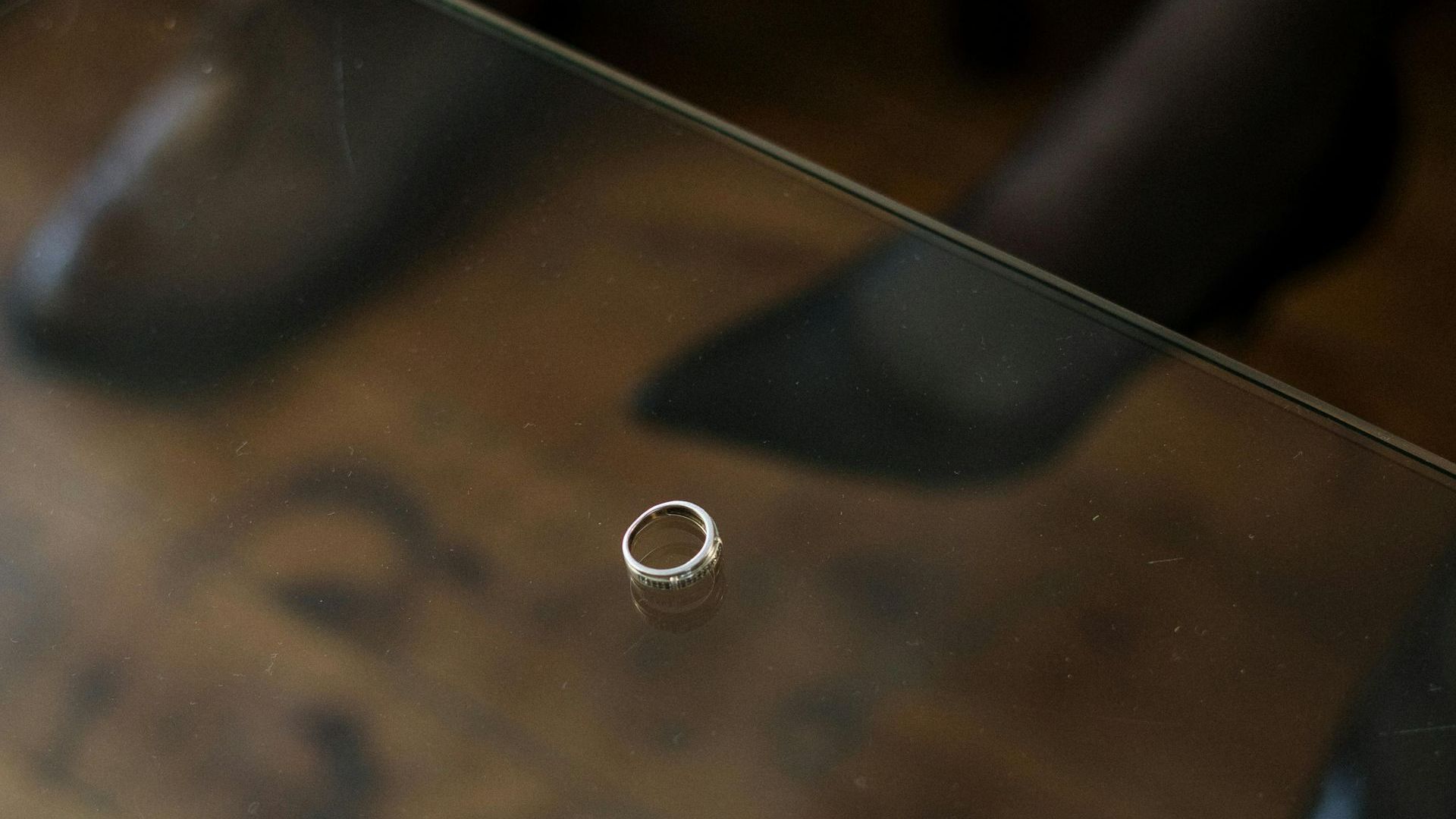 A small silver ring on a brown blurred surface.