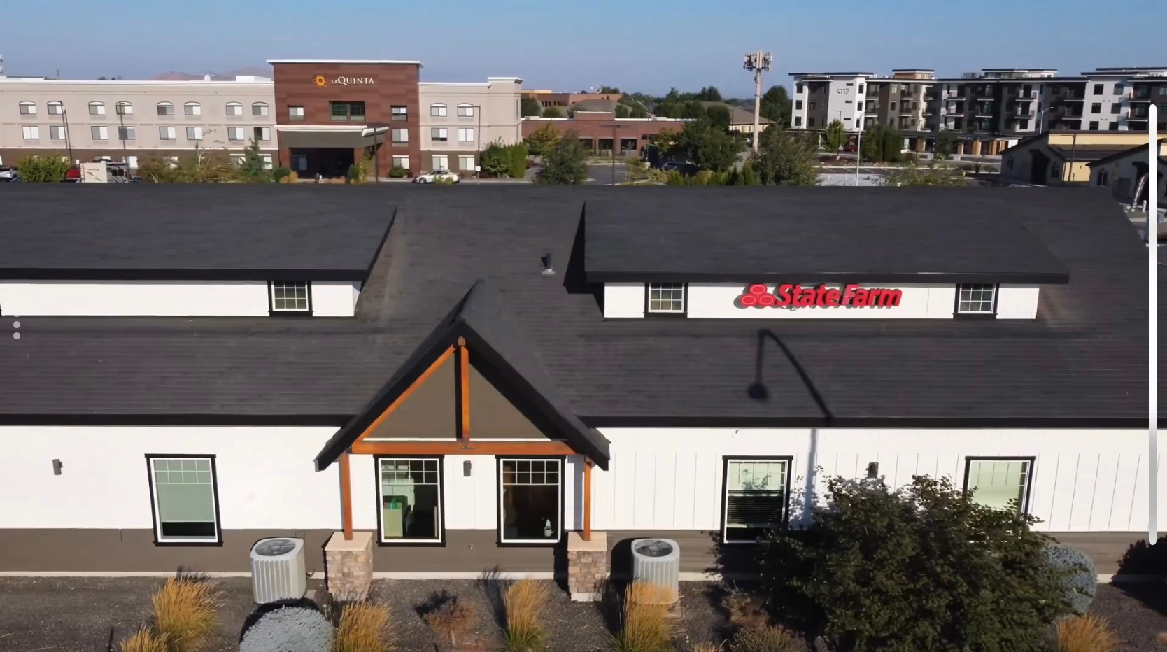 Exterior of a white commercial building with a black roof; 