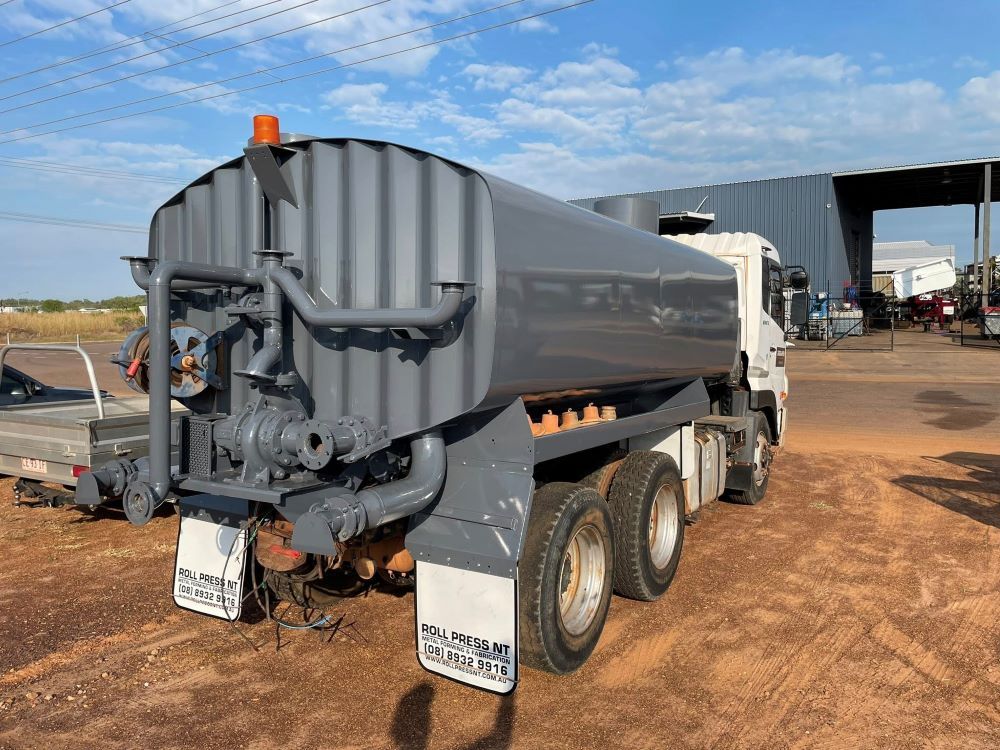 A Large Tanker Truck Is Parked in A Dirt Lot in Front of A Building — Diggamen Civil Contracting in Tivendale, NT
