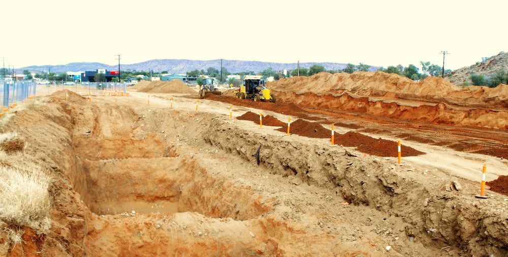 A Construction Site With a Lot of Dirt and a Bulldozer in the Background — Diggamen Civil Contracting in Tivendale, NT