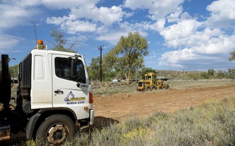 A White Truck on the Side of a Road That Says Grid — Diggamen Civil Contracting in Tivendale, NT