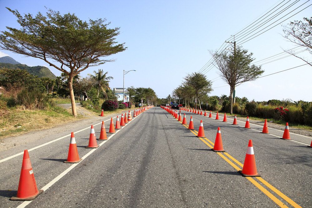 A Row of Orange Traffic Cones on the Side of a Road — Diggamen Civil Contracting in Palmerston, NT